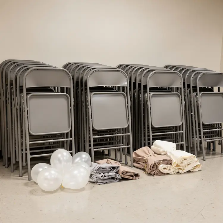 Stacked Folding Chairs and Event Supplies in Venue