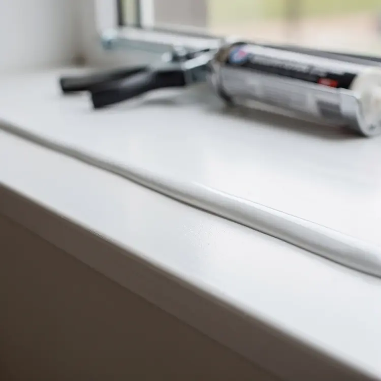 Caulking Gun and Sealant on Window Sill