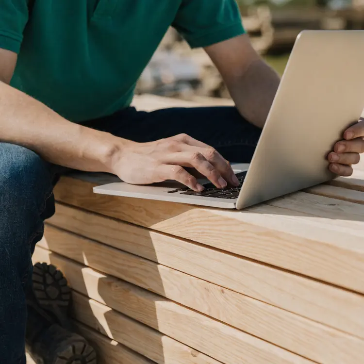 Contractor Working on Laptop at Lumber Yard