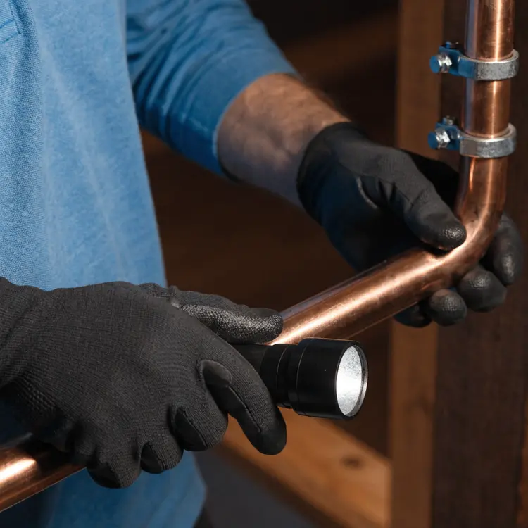 Plumber Inspecting Copper Pipes
