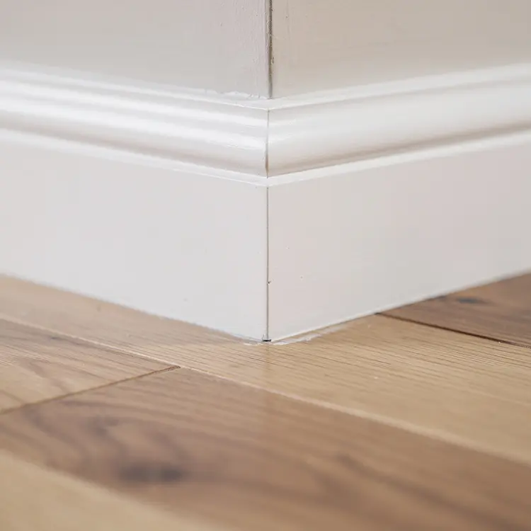 Freshly Painted White Baseboard on Hardwood Floor