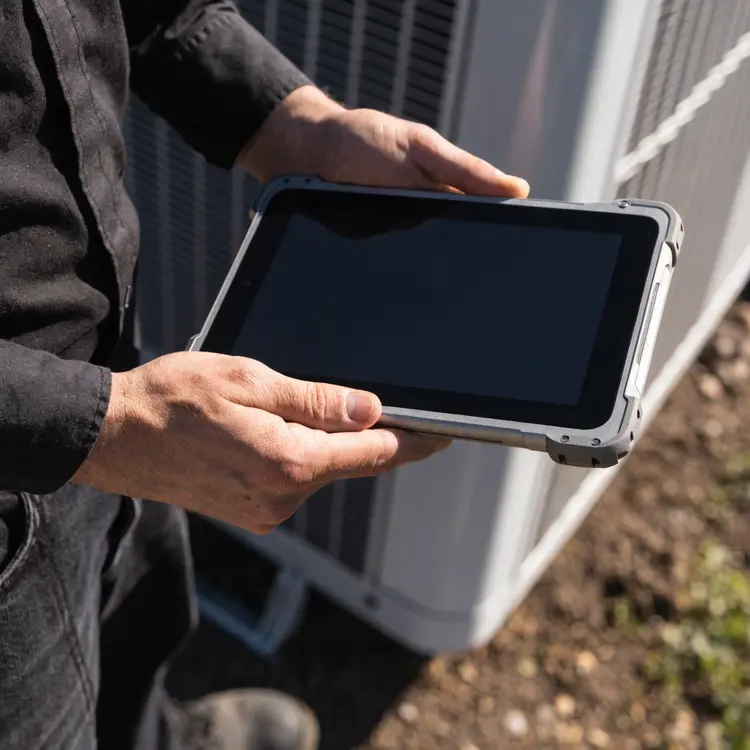 HVAC Technician with Tablet at AC Unit