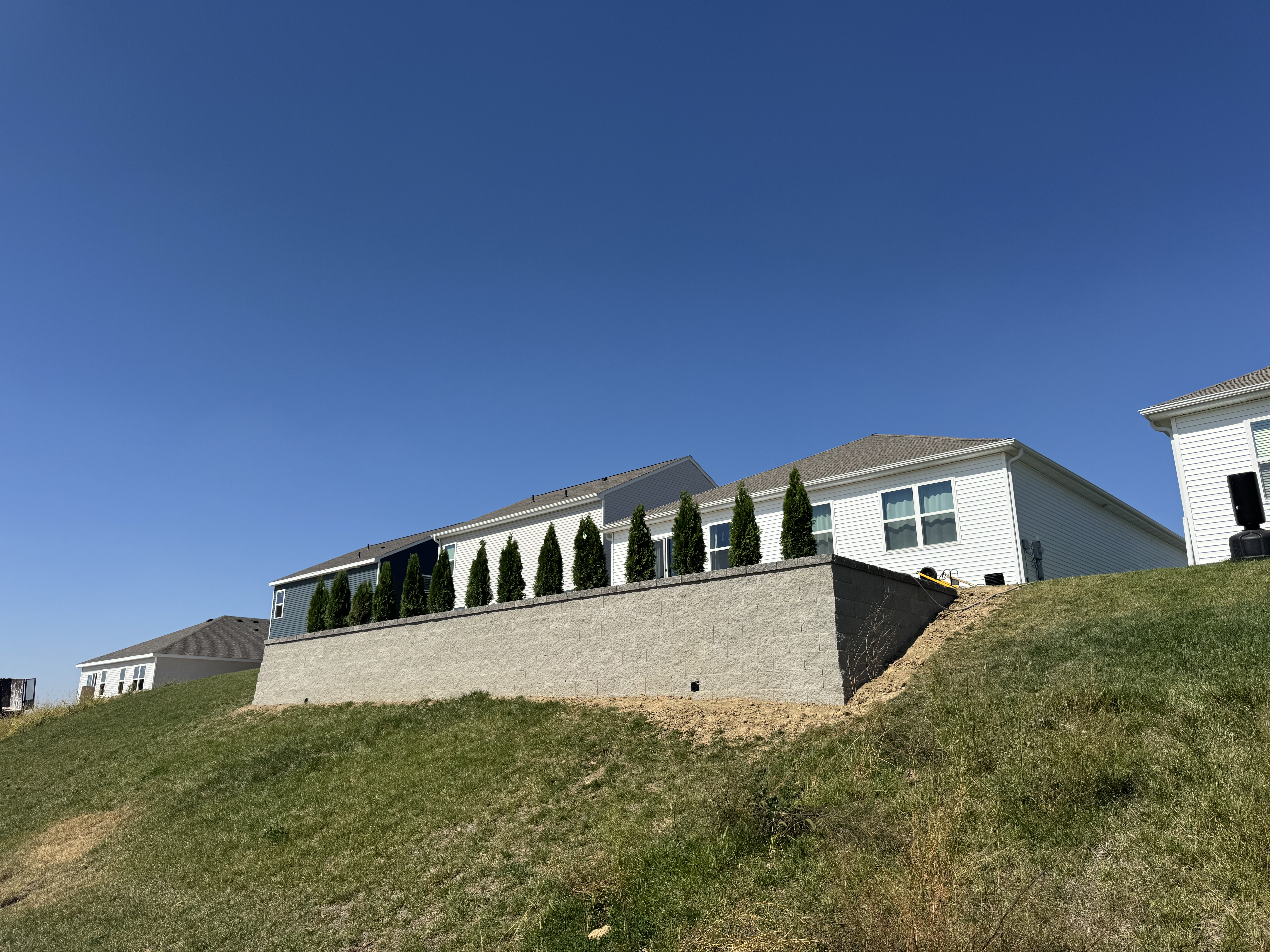 Block Retaining Wall with Evergreen Landscaping