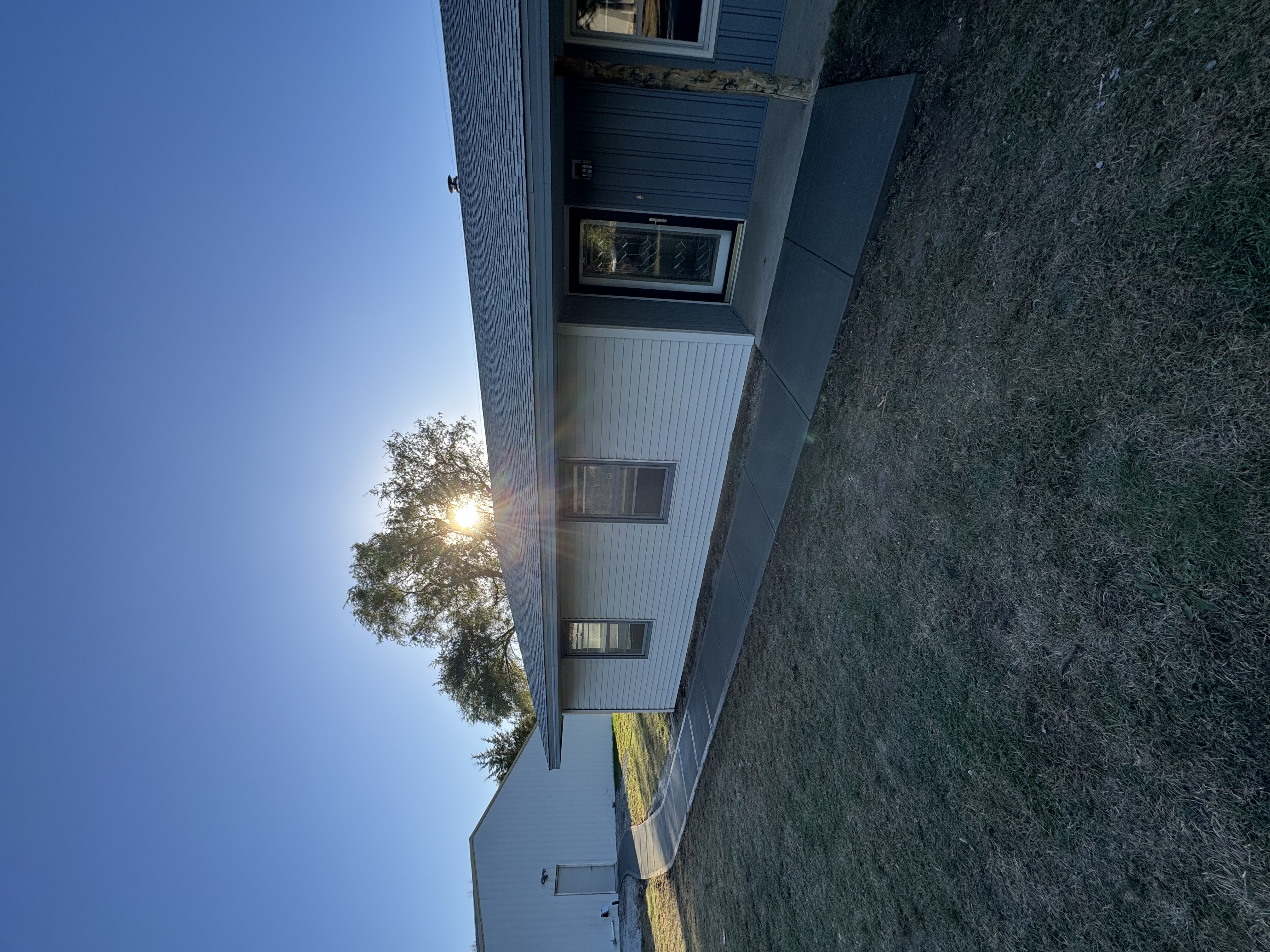 Ranch Home Exterior with Concrete Walkway & Lawn