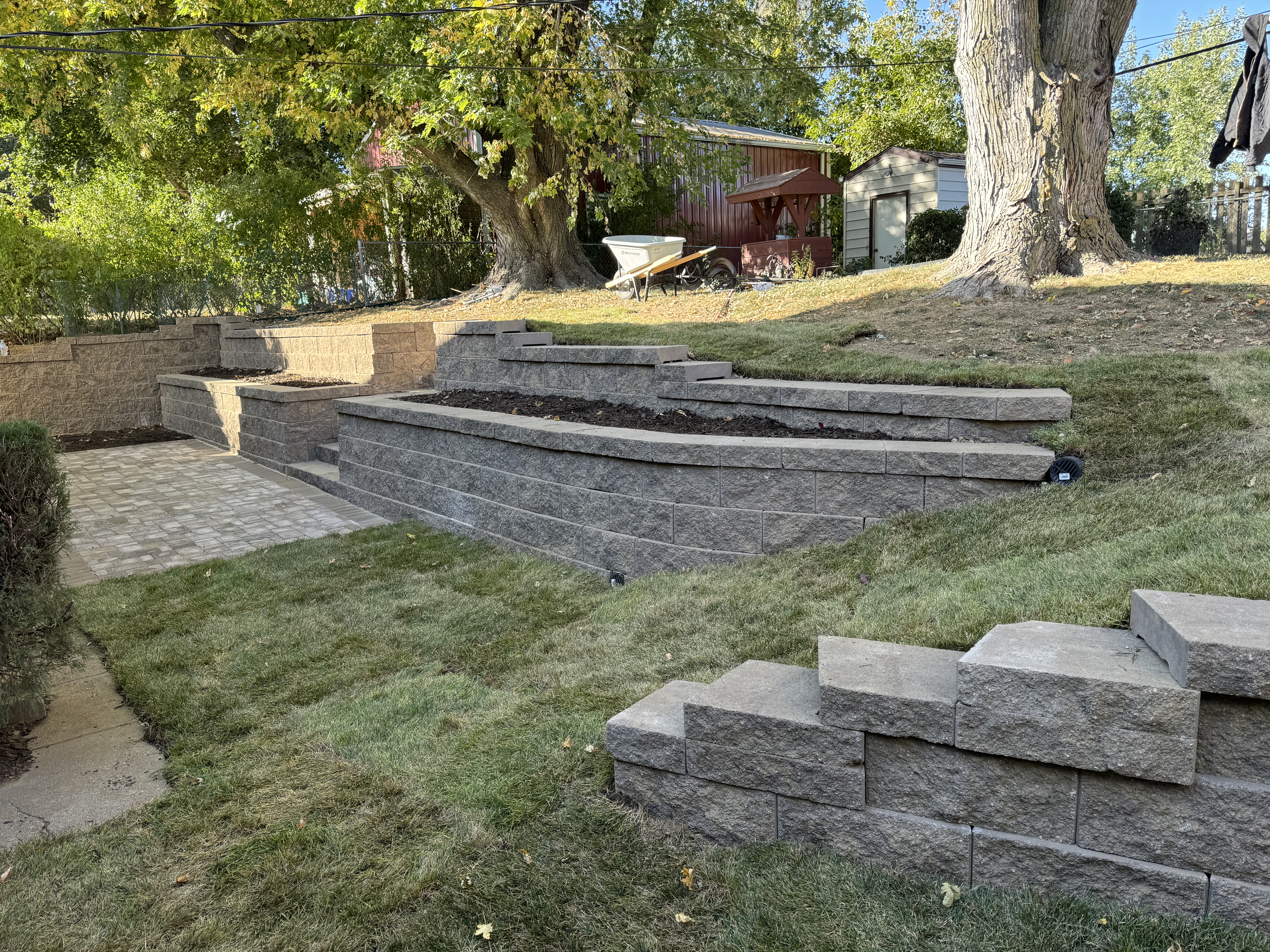 Tiered Block Retaining Walls with Curved Planters and Paver Patio